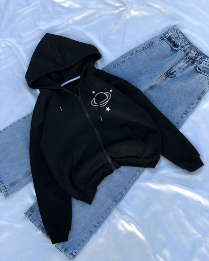 Black hoodie with a planet design on denim jeans against a white background