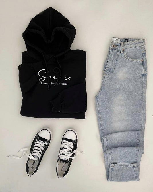 Black hoodie with text, light blue jeans, and black sneakers on a white background
