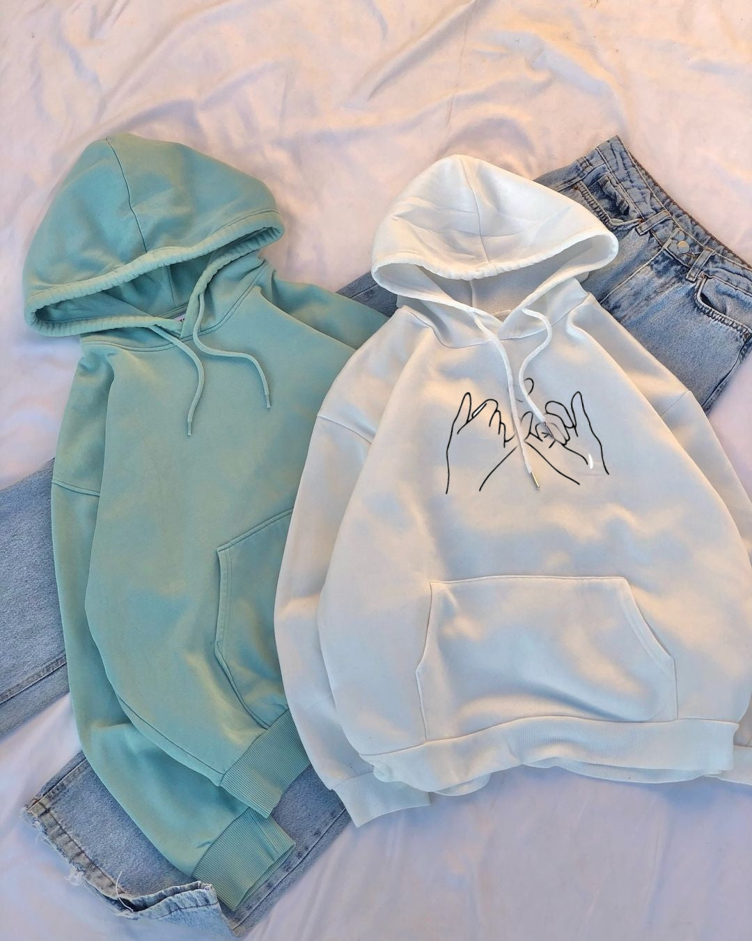 Two hoodies, one WHITE and one green, on a white background.